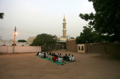مجموعة من السودانيين يقيمون إفطارًا جماعيًا في الطريق وهي من العادات والتقاليد في رمضان