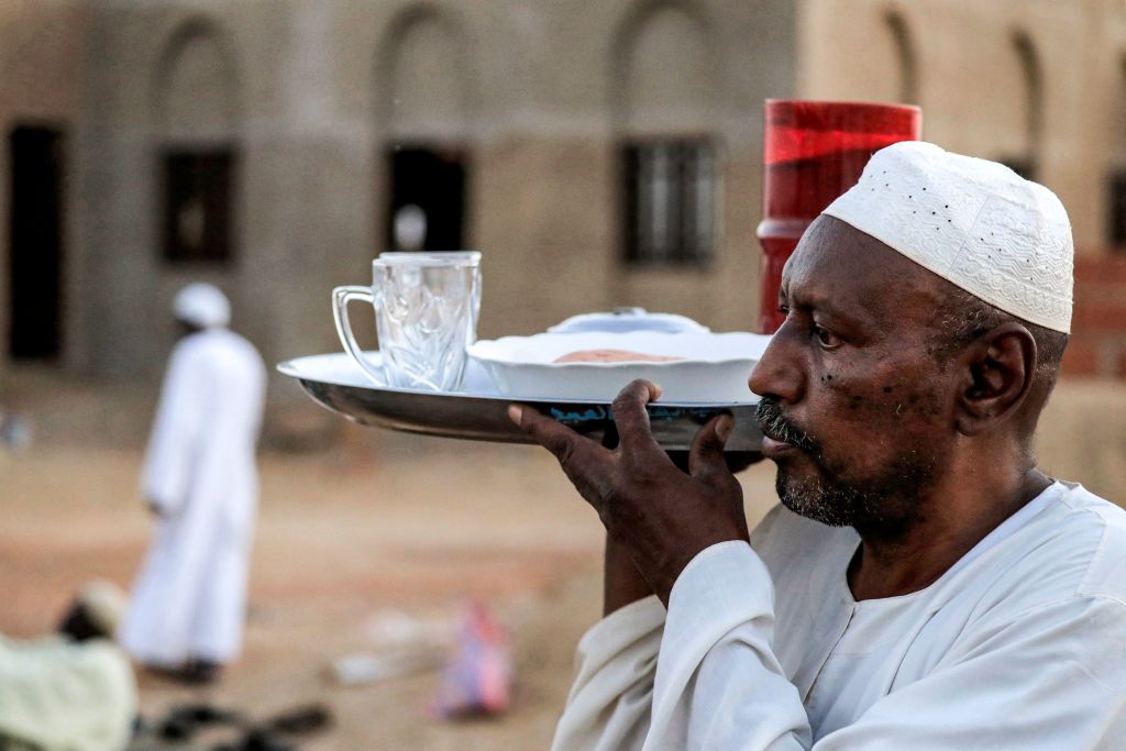 يحمل الرجال سفرة رمضان السودانية "صينية رمضان" للشوارع ضمن عادات رمضان في السودان
