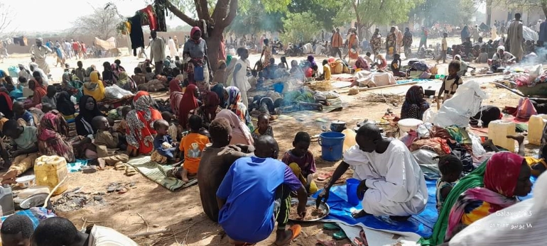 مجموعة من الأشخاص يفترشون الأرض في معسكرات النزوح في دارفور 