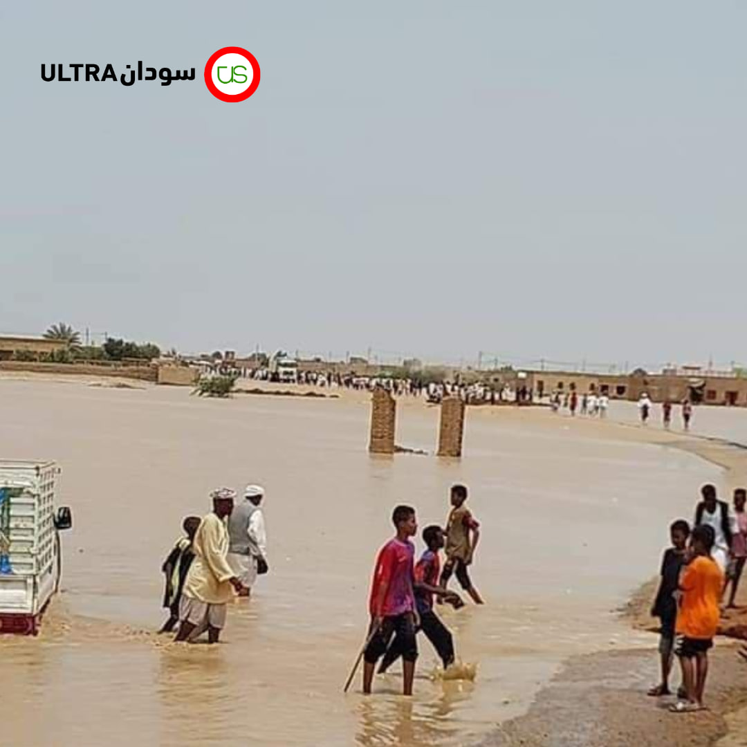 مواطنون يخوضون في مياه السيول في ولاية نهر النيل