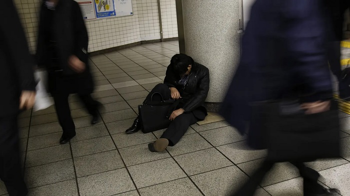 (Getty) قد لا يجد العامل الياباني وقتًا للراحة إلا في محطة القطارات 