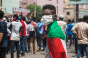 متظاهر متوشح بعلم السودان