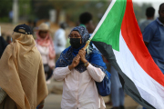 متظاهرة تحمل علم السودان في احتجاجات الخرطوم ضد الانقلاب