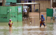 طفلتان تخوضان في مياه السيول والأمطار في المناقل بولاية الجزيرة
