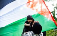 سيدة تحمل طفلًا - كوفية - علم فلسطين