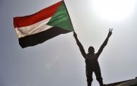 طفل يحمل علم السودان في مظاهرة