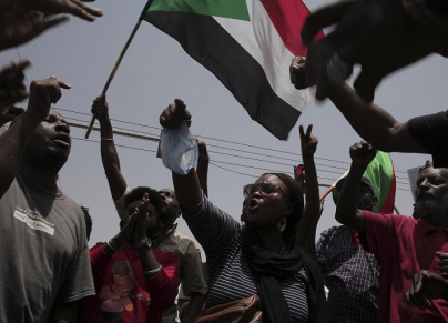 محتجون سودانيون يلوحون بعلم السودان