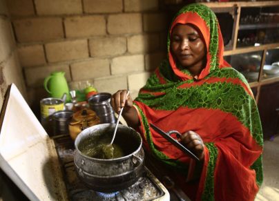 سيدة سودانية تطبخ الخضرة