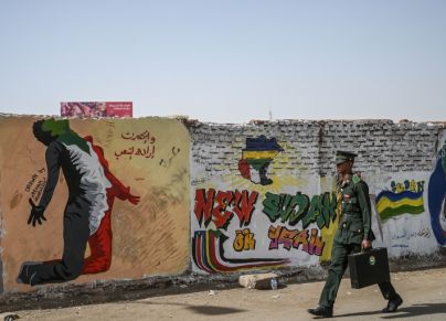 طالب حربي أمام جدارية