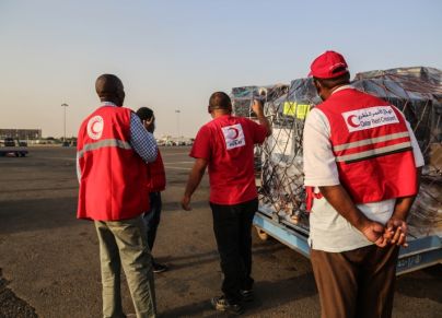 عاملون في الهلال الأحمر القطري يستلمون مساعدات إنسانية إلى السودان