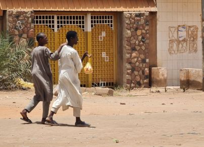 شابان يحملان بعض الرغيف في أحد شوارع الخرطوم خلال الحرب