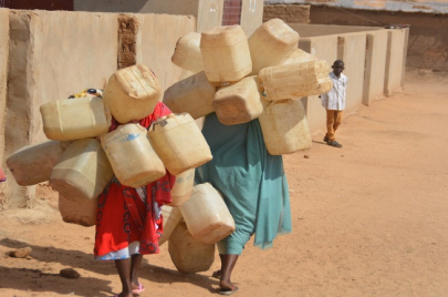نساء يحملن أواني مياه
