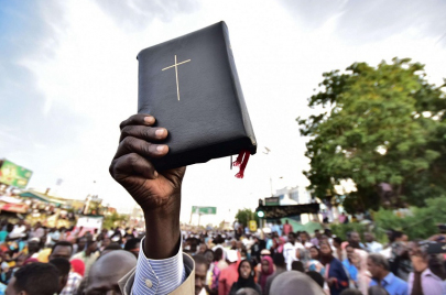 رجل يحمل الكتاب "المقدس" في مظاهرة للمسيحيين بالخرطوم