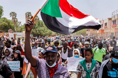 رجل يحمل علم السودان في مظاهرة رافضة للحكم العسكري