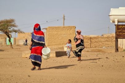 نساء في طريقهن إلى جلب المياه بالأواني في أحد أحياء أم درمان