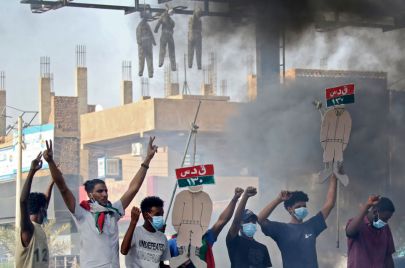 محتجون يحملون لوحات سيارات قوات الدعم السريع المحطمة عقب فض الاعتصام بالخرطوم في العام 2019 (Getty)