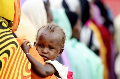 أم تحمل طفلتها في السودان