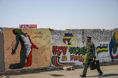 طالب حربي أمام جدارية