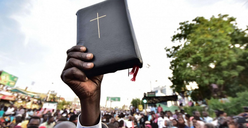 رجل يحمل الكتاب "المقدس" في مظاهرة للمسيحيين بالخرطوم