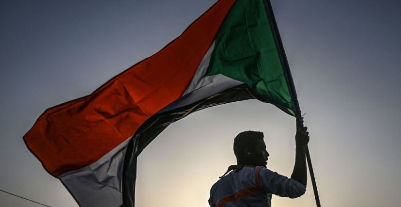 شاب يحمل علم السودان