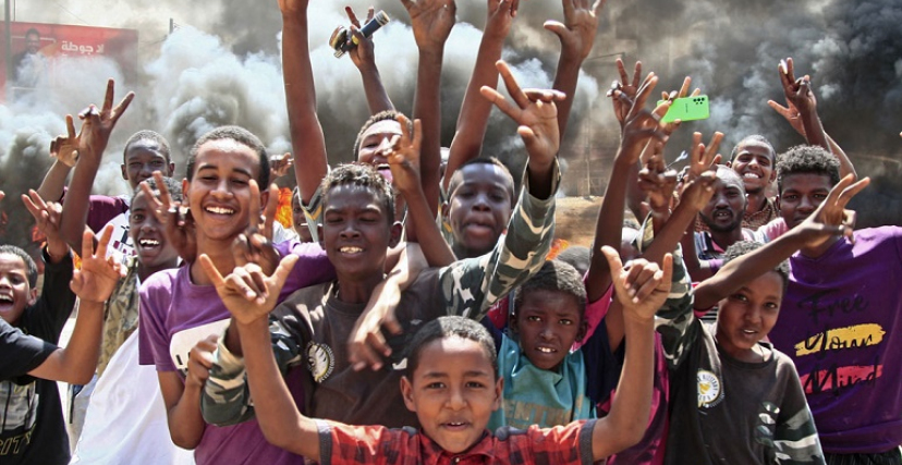 أطفال سودانيون يلوحون بعلامة النصر