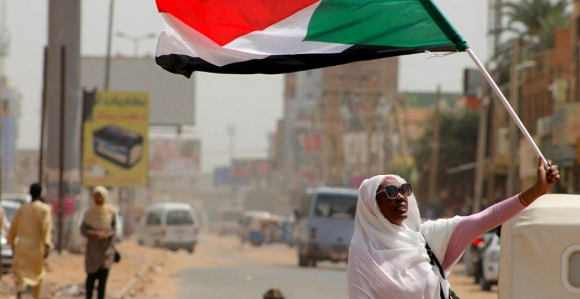 محتجة تحمل علم السودان