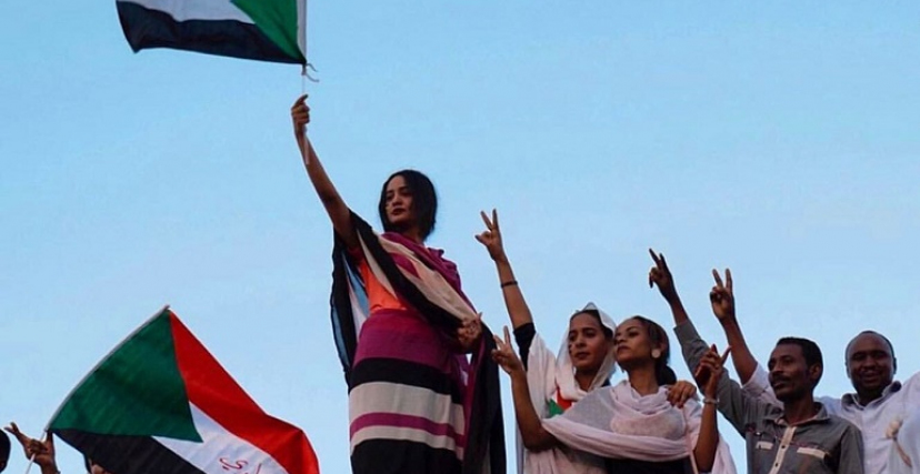 نساء سودانيات يحملن علم السودان