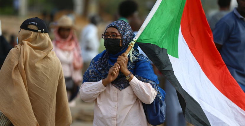 متظاهرة تحمل علم السودان في احتجاجات الخرطوم ضد الانقلاب
