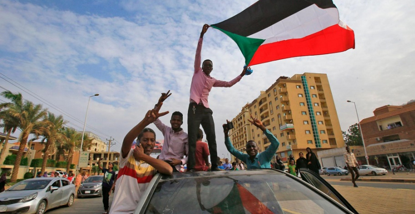 محتجون يحملون علم السودان
