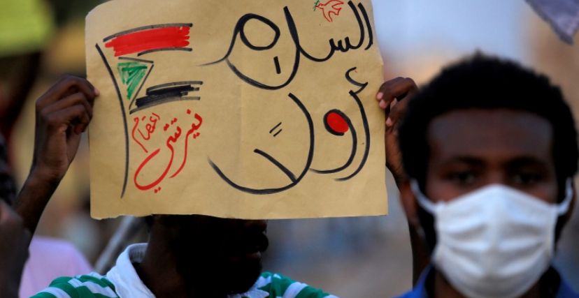 محتج يرفع لافتة عليها عبارة "السلام أولاً" في السودان
