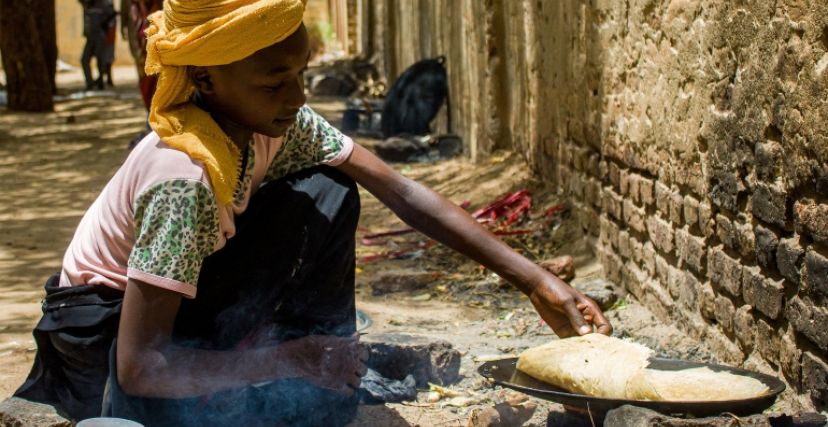 طفلة تطبخ في معسكر إيواء للنازحين