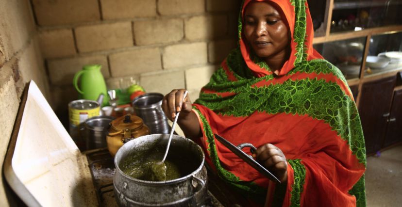 سيدة سودانية تطبخ الخضرة