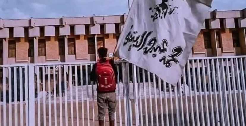 محتج يحمل لافتة بها صورة الشهيد الدينمو