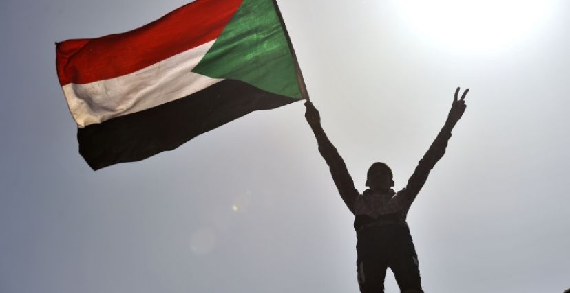 طفل يحمل علم السودان في مظاهرة