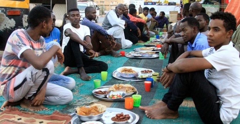 صائمون في انتظار أذان المغرب وهم جالسون حول سفرة رمضان في السودان