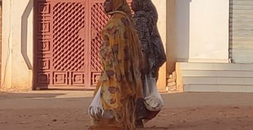 سيدتان من السودان تحملان مواد غذائية في الحرب