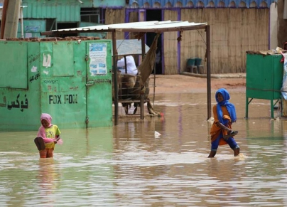 طفلتان تخوضان في مياه السيول والأمطار في المناقل بولاية الجزيرة