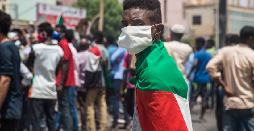 متظاهر متوشح بعلم السودان